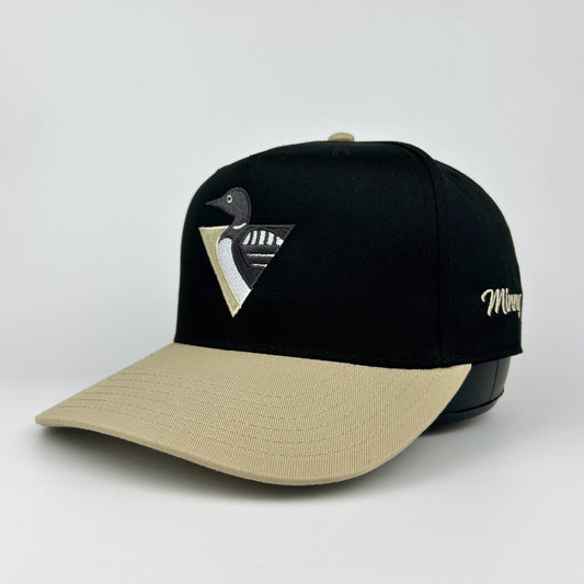 Black and beige cap with a logo on a light gray background