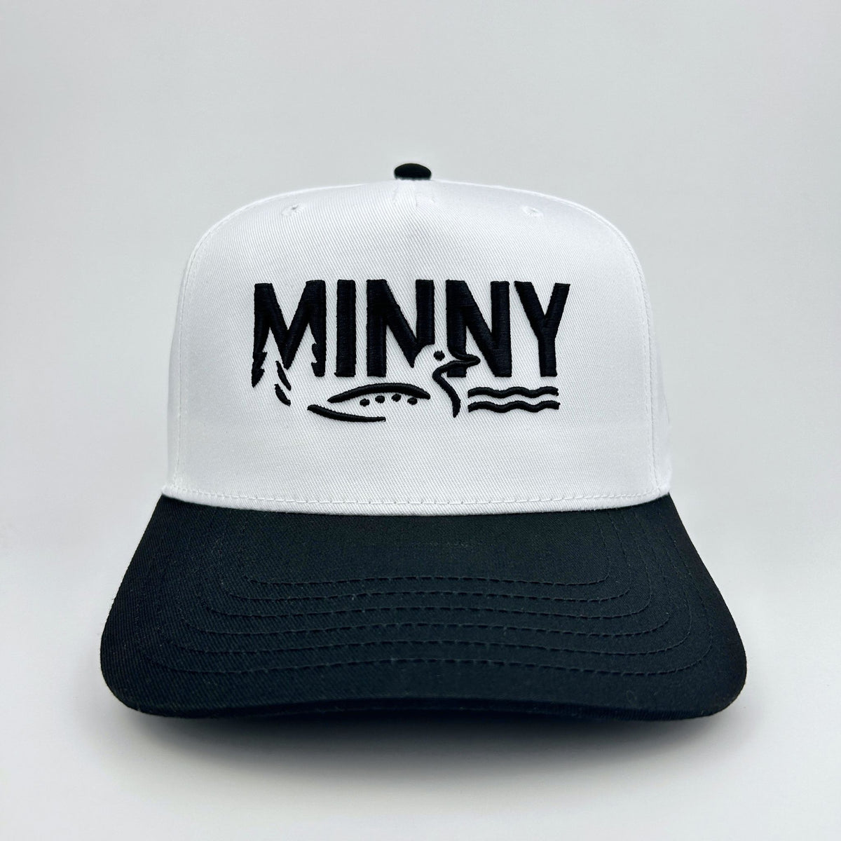 White and black cap with 'MINNY' logo on a light gray background