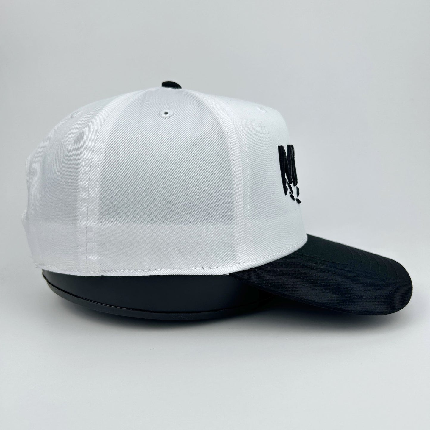 White and black cap with a logo on a light gray background