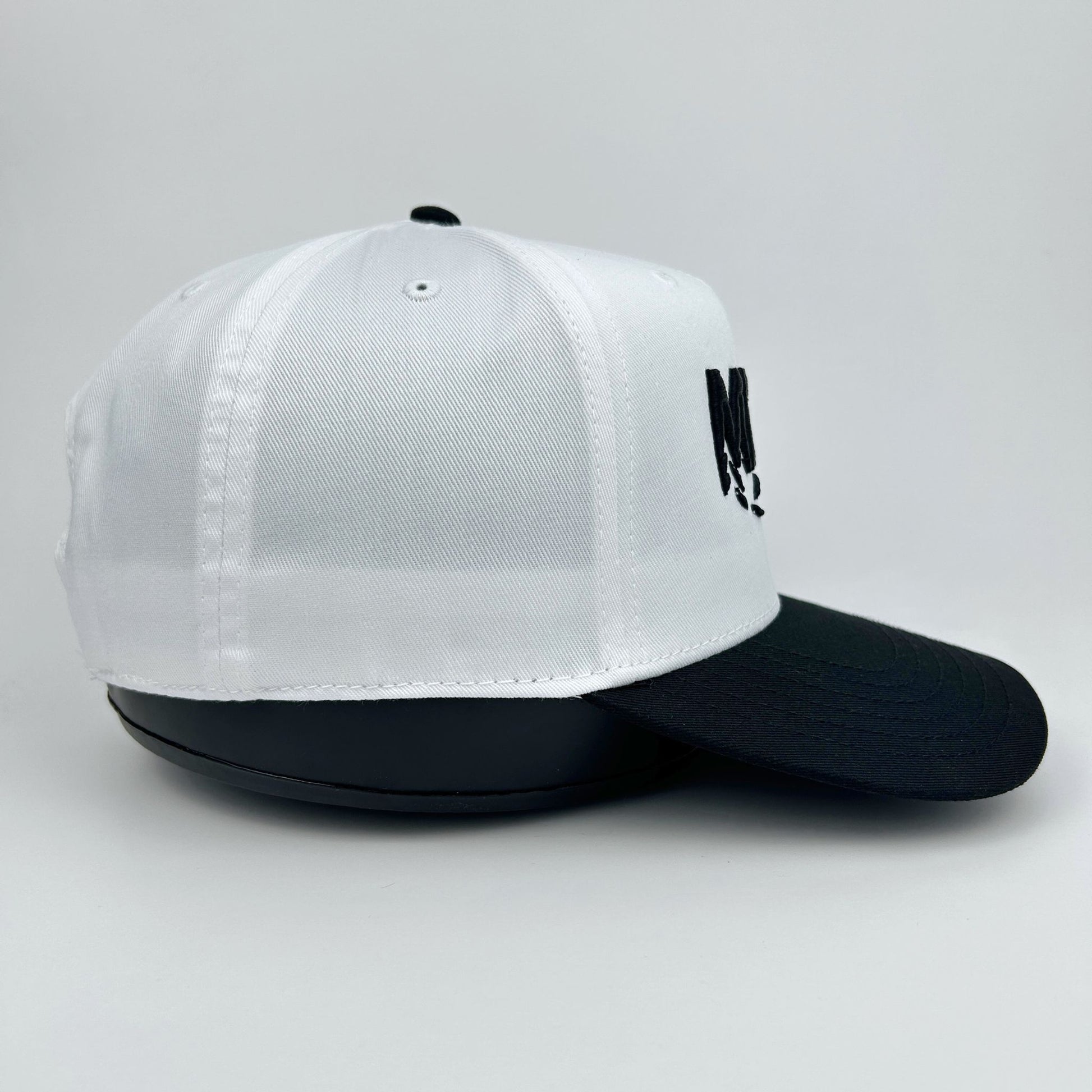 White and black cap with a logo on a light gray background