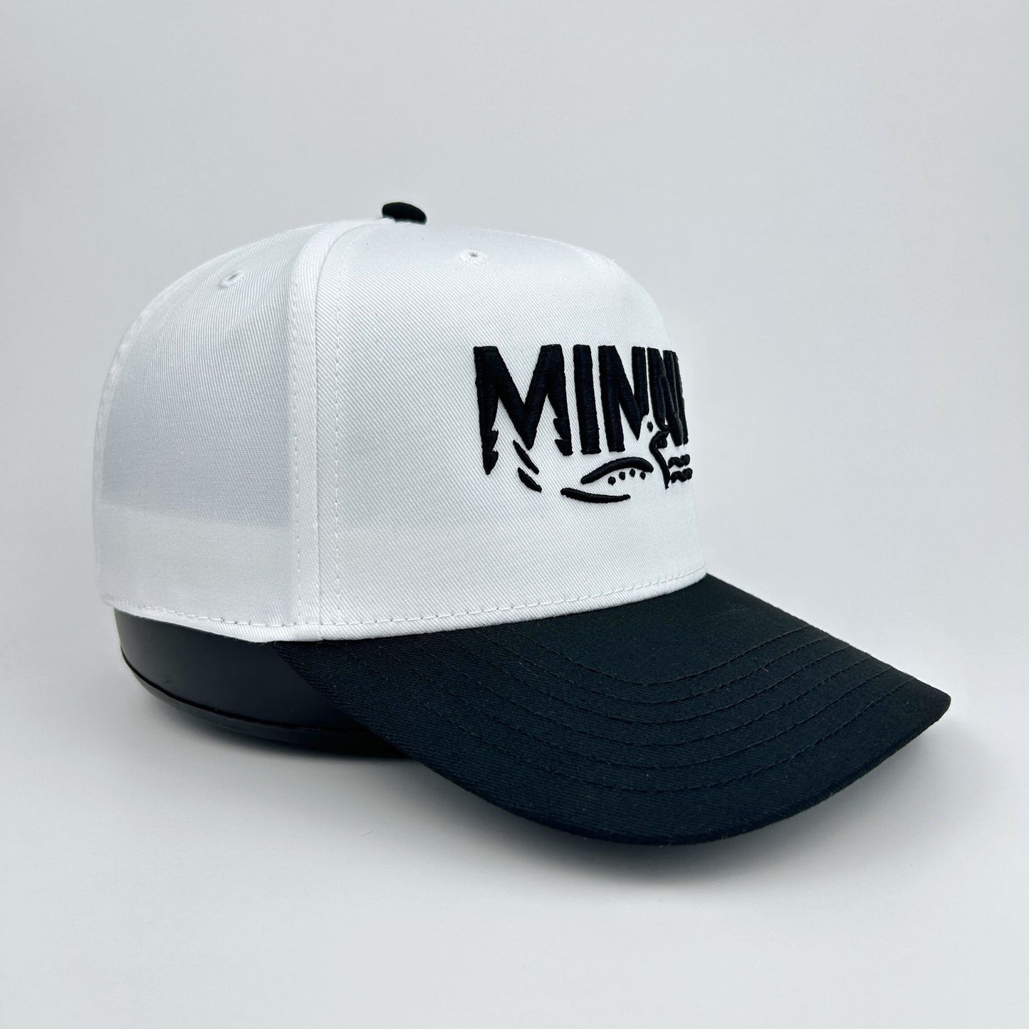 White and black cap with 'Minny' logo on a light gray background
