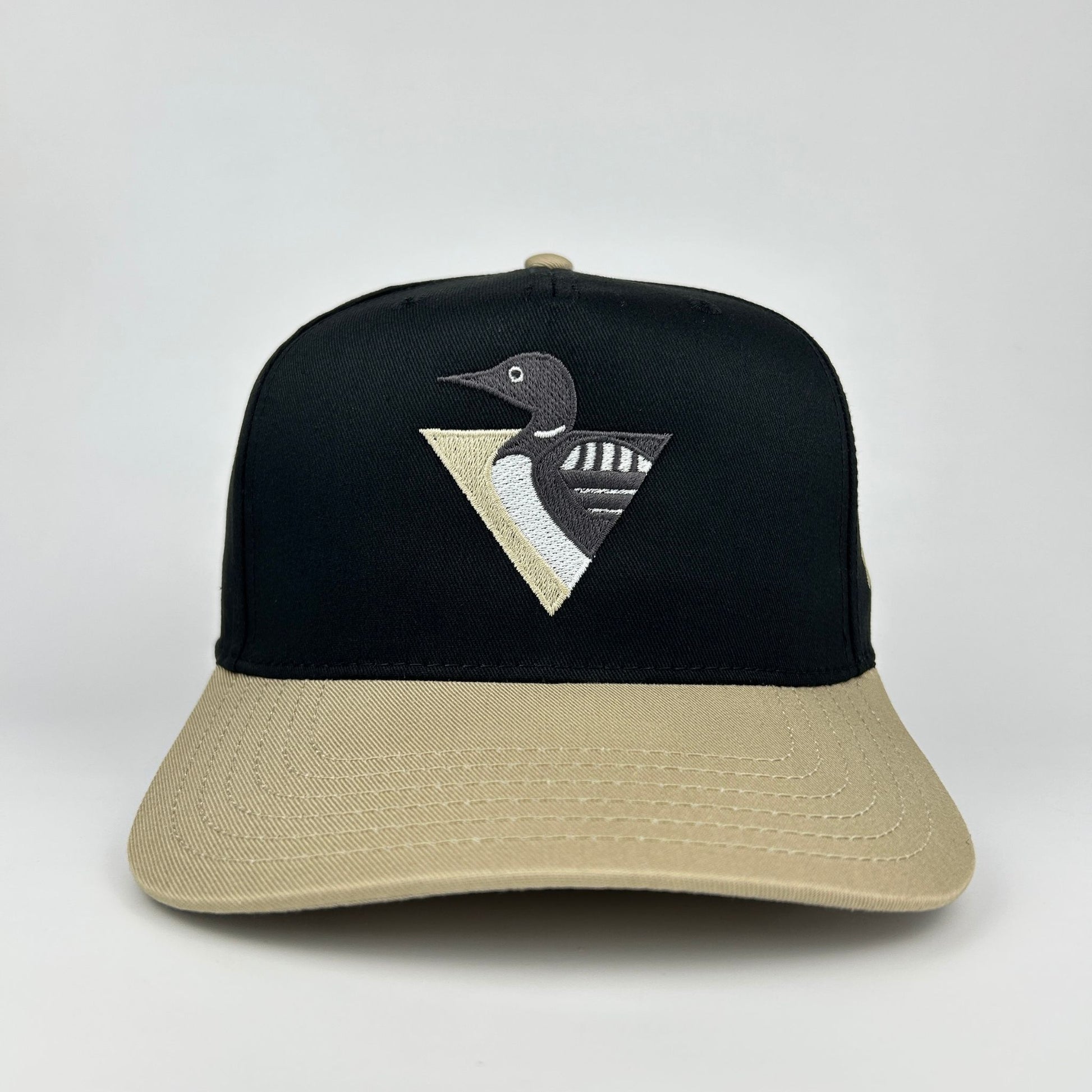 Black and beige cap with a loon emblem on a white background