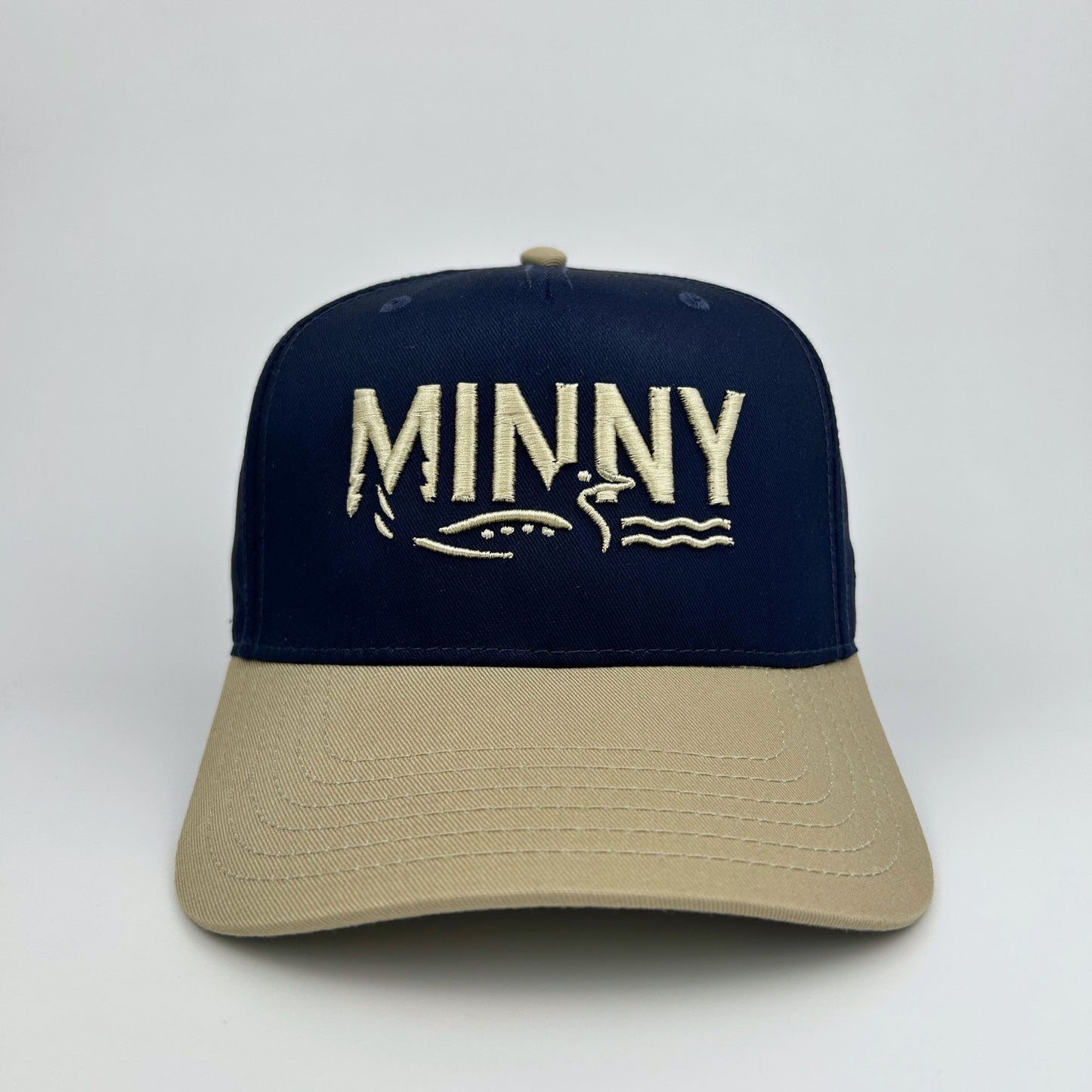 Navy and beige cap with 'MINNY' branding on a white background