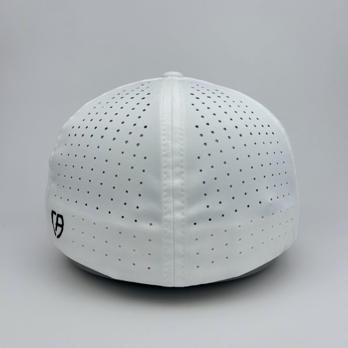 White cap with black perforations on a gray background