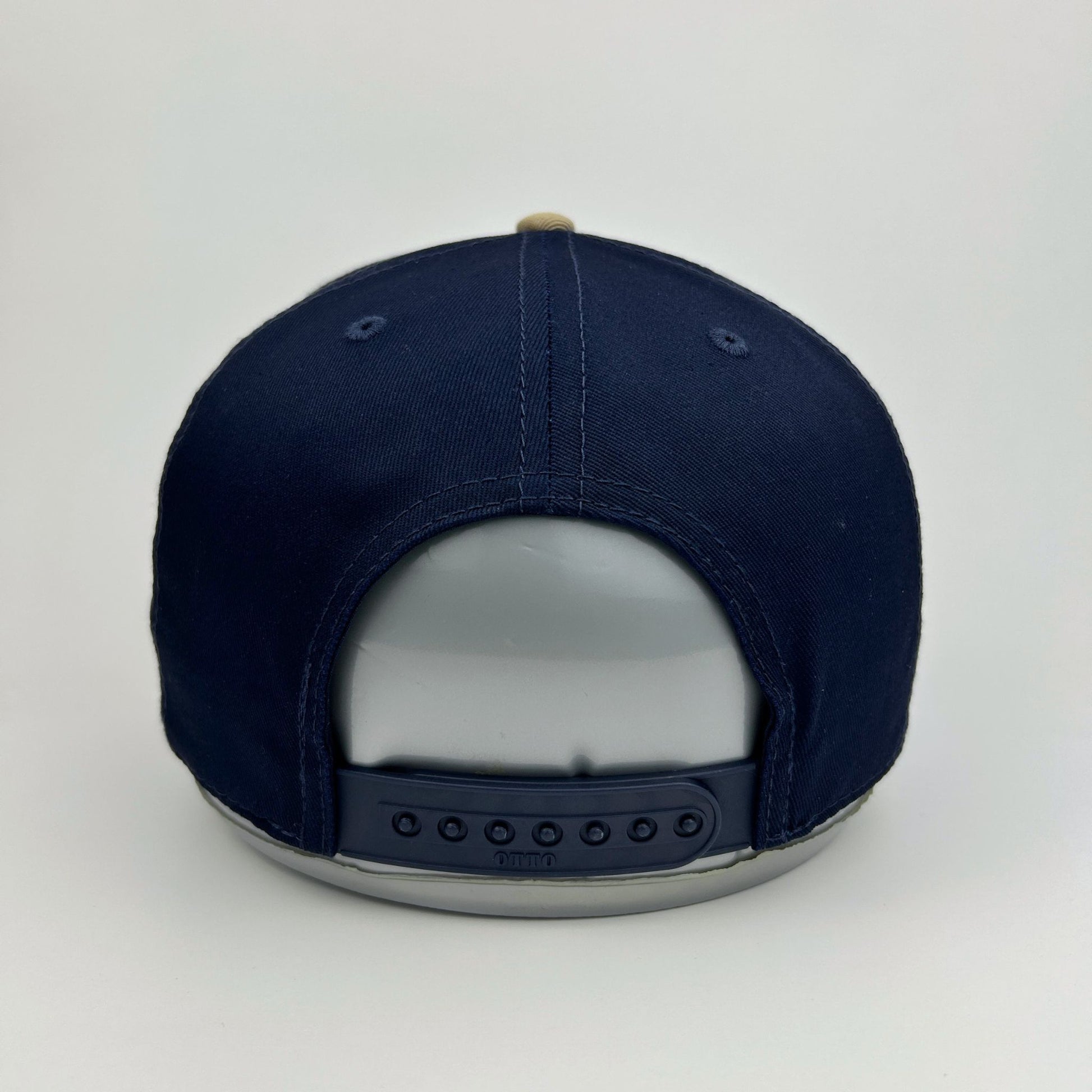 Navy blue cap with a reflective back on a light gray background