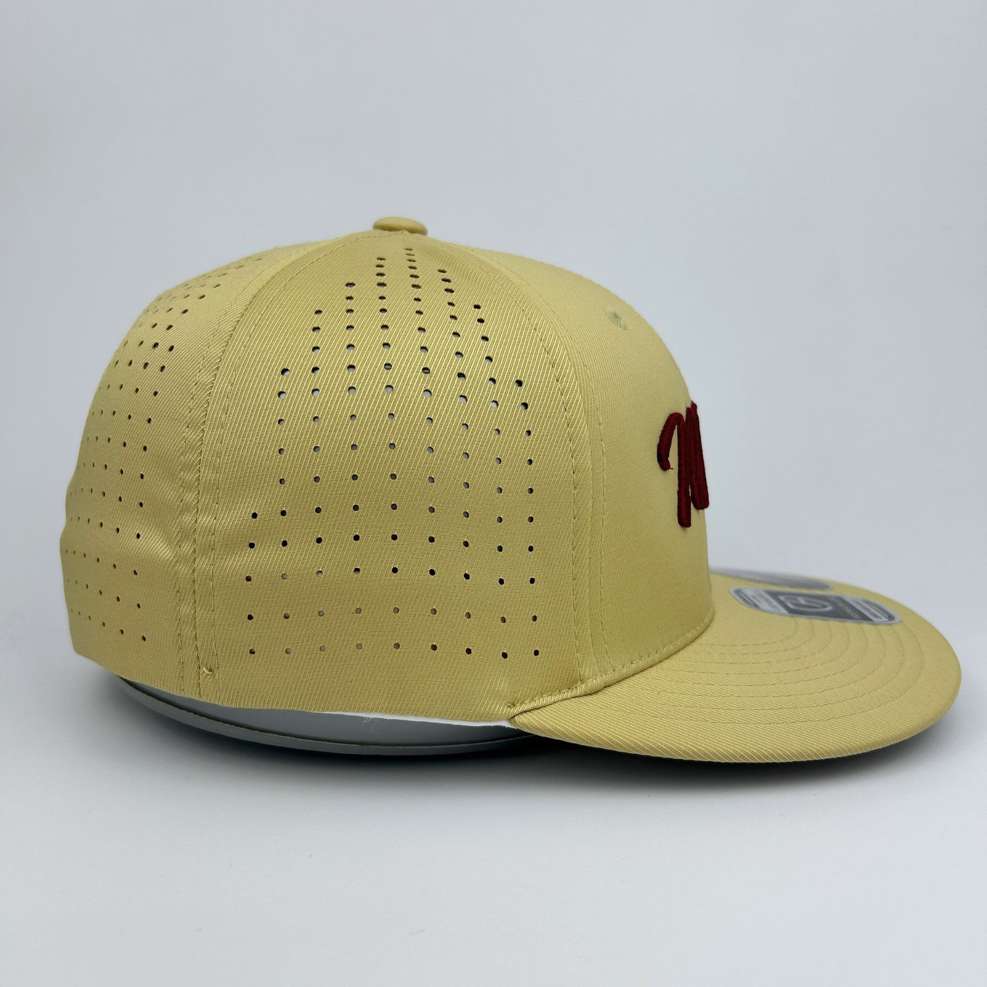 Beige cap with perforated design on a light gray background