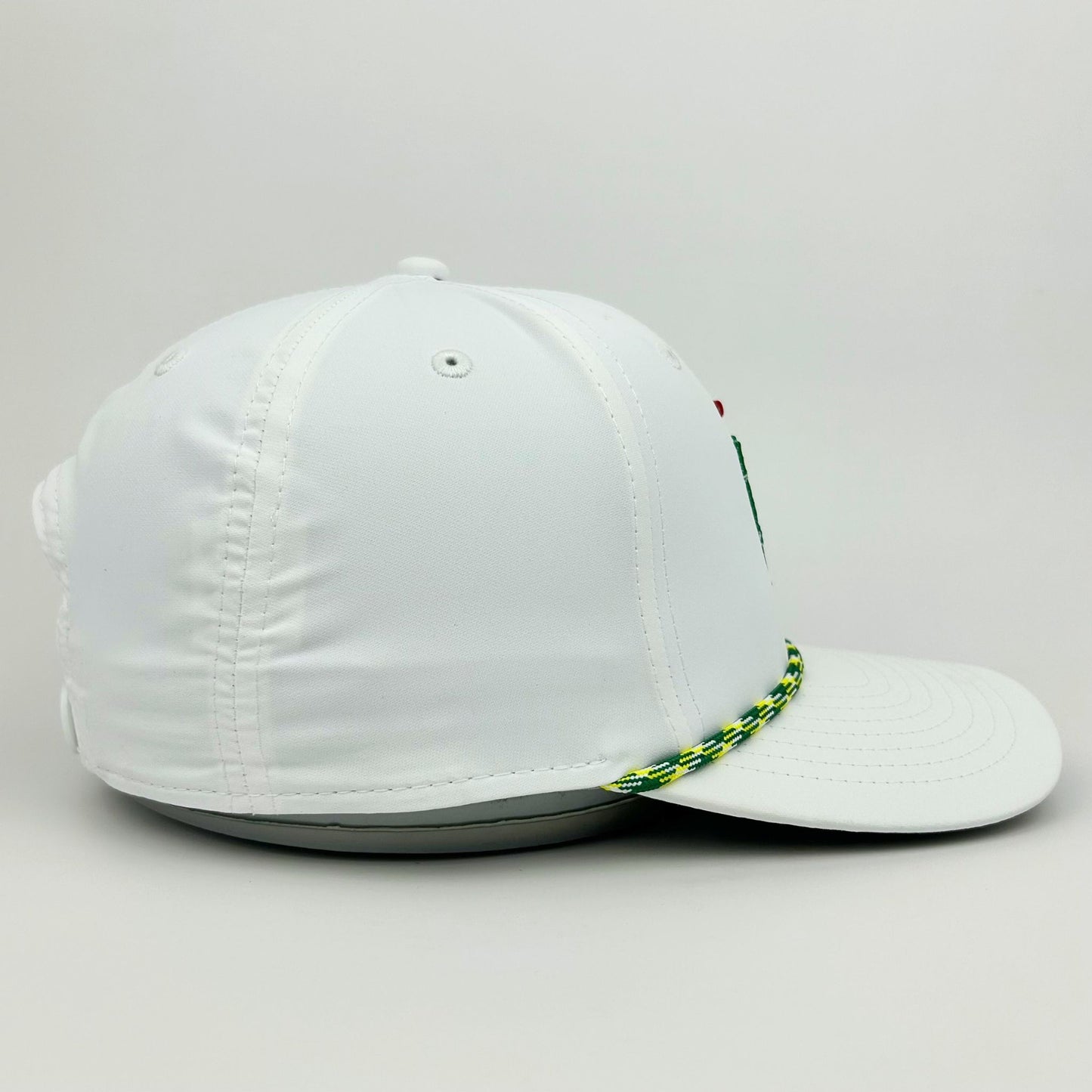 White cap with a green and yellow braided strap on a light gray background