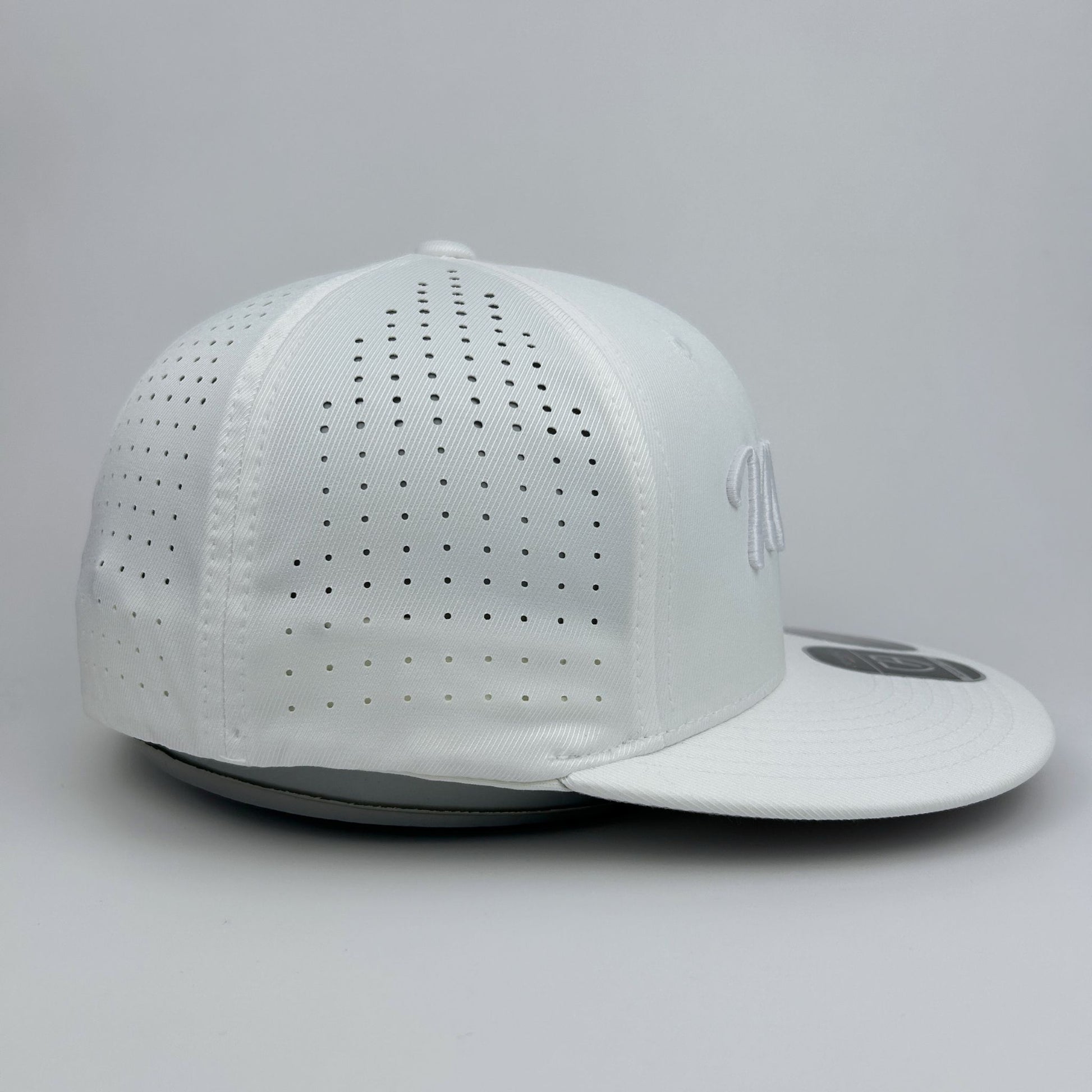 White baseball cap with perforated design on a gray background