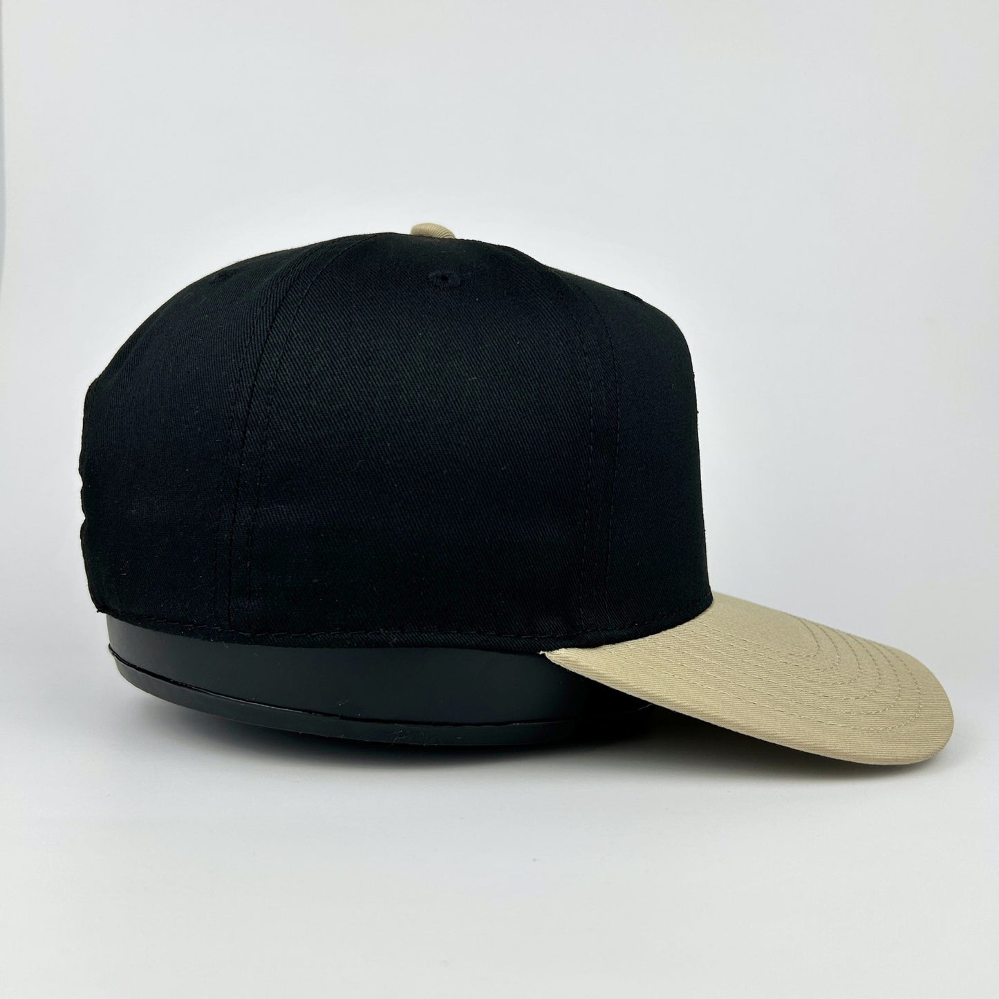 Black cap with beige visor on a white background