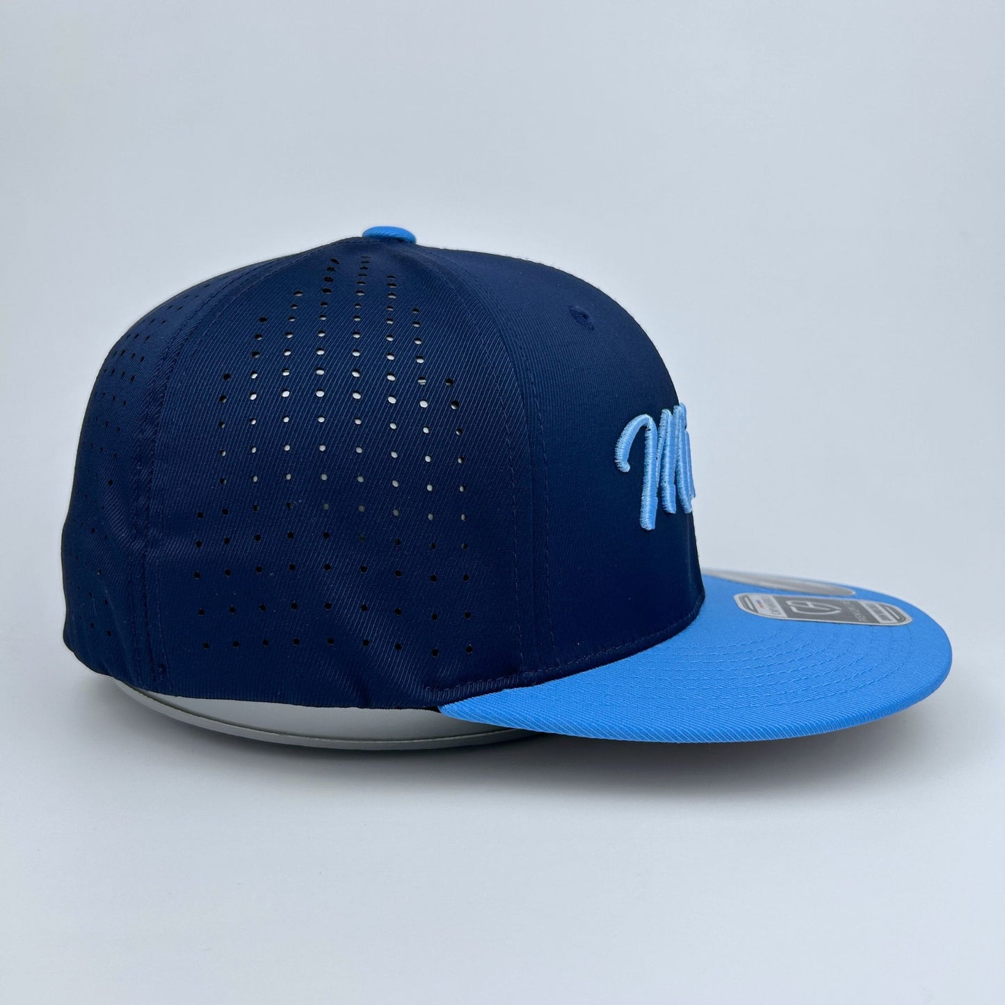 Blue baseball cap with perforated design on a light gray background