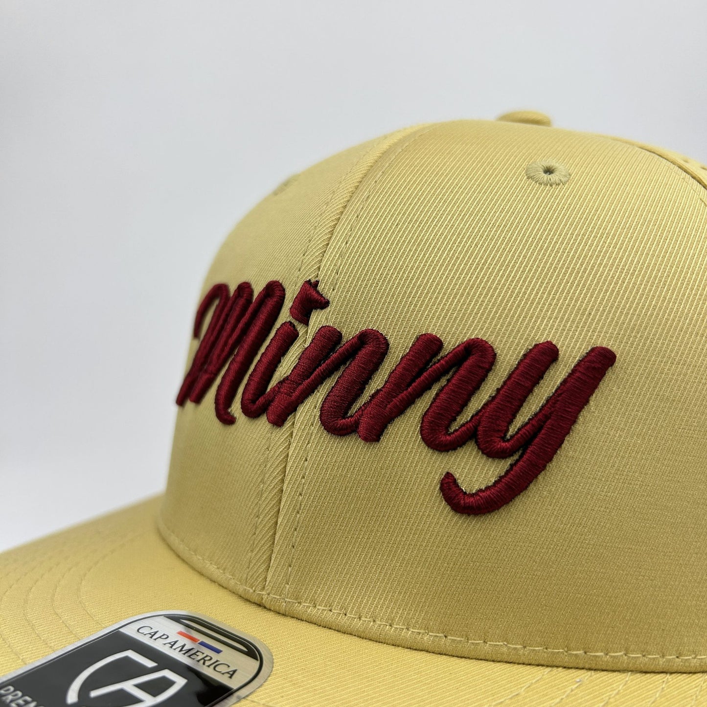Beige cap with red 'Minny' embroidery on a white background