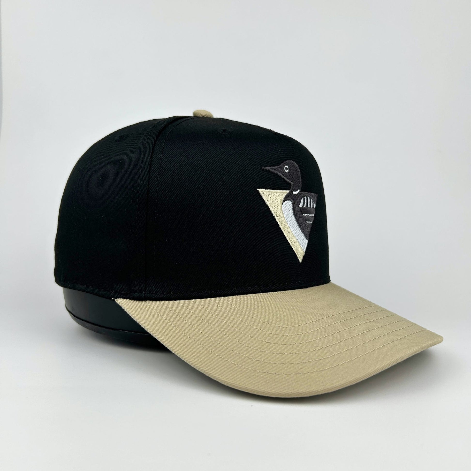 Black and beige cap with a loon logo on a white background