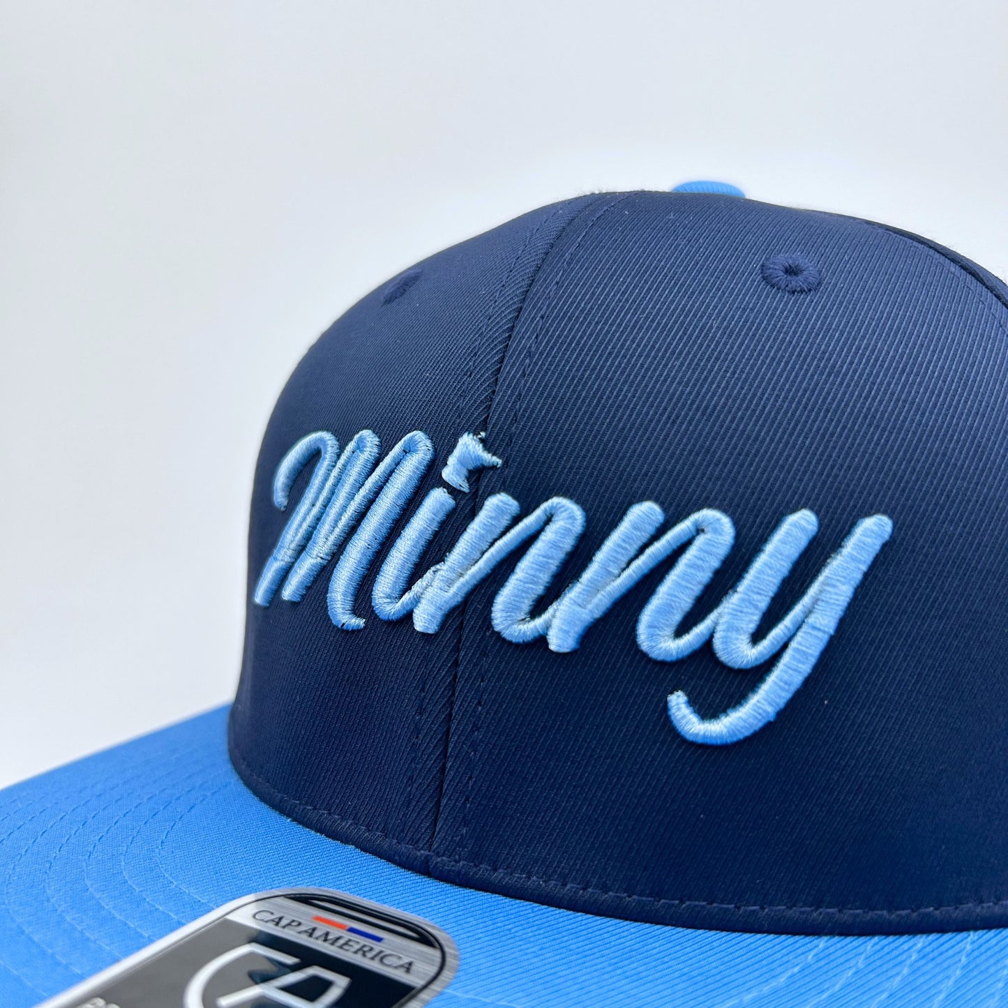 Blue cap with 'Minny' text on a white background