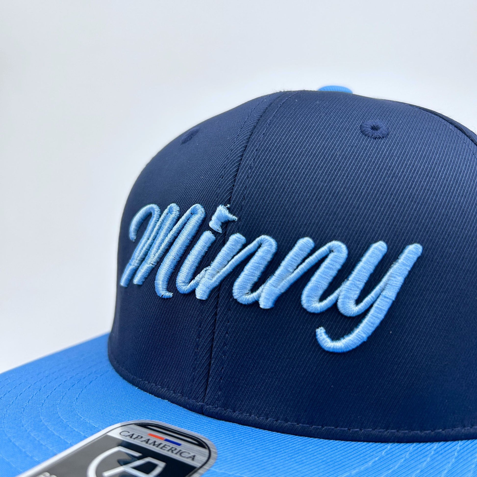 Blue cap with 'Minny' text on a white background