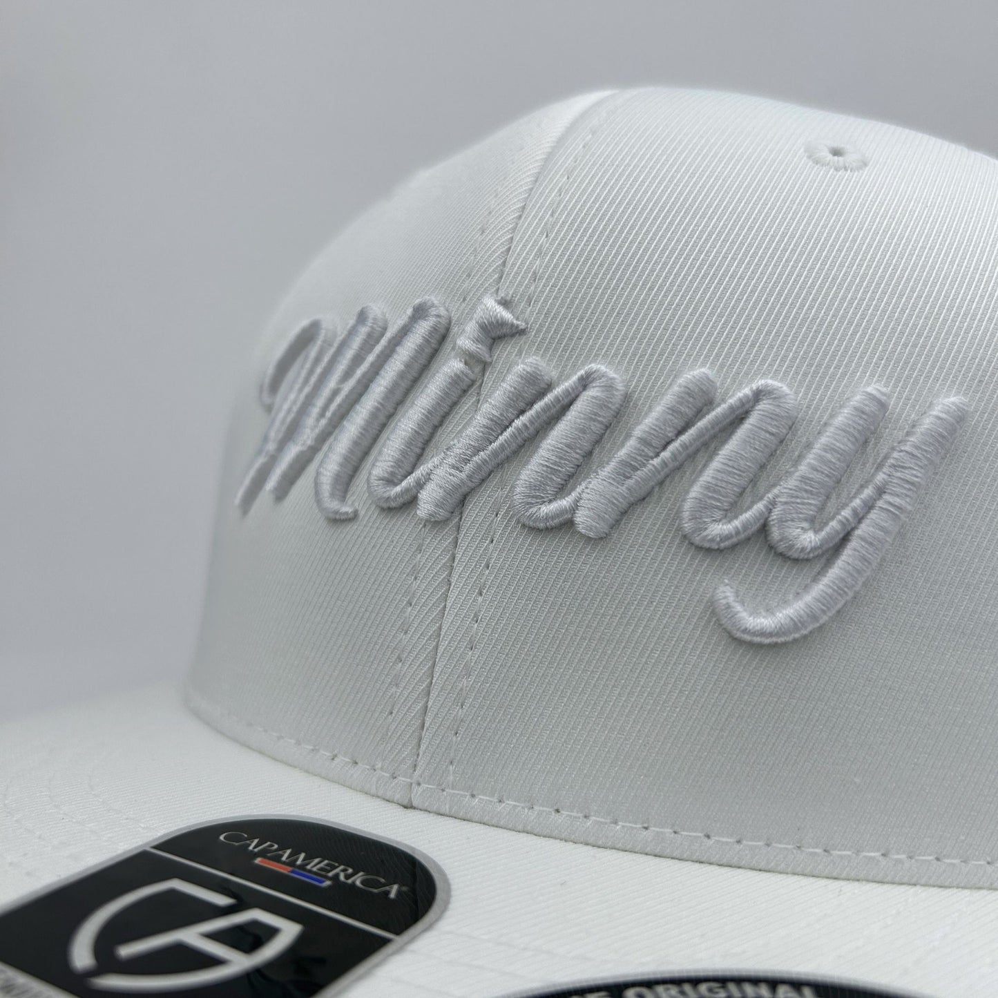 White cap with 'Minny' embroidery on a light gray background
