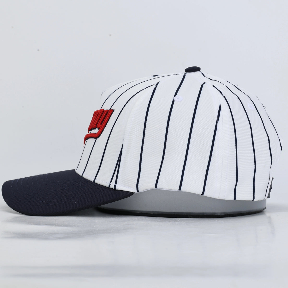 A baseball cap featuring a white crown with thin navy pinstripes, a dark navy curved brim, and a red embroidered 'Minny' logo on the front.