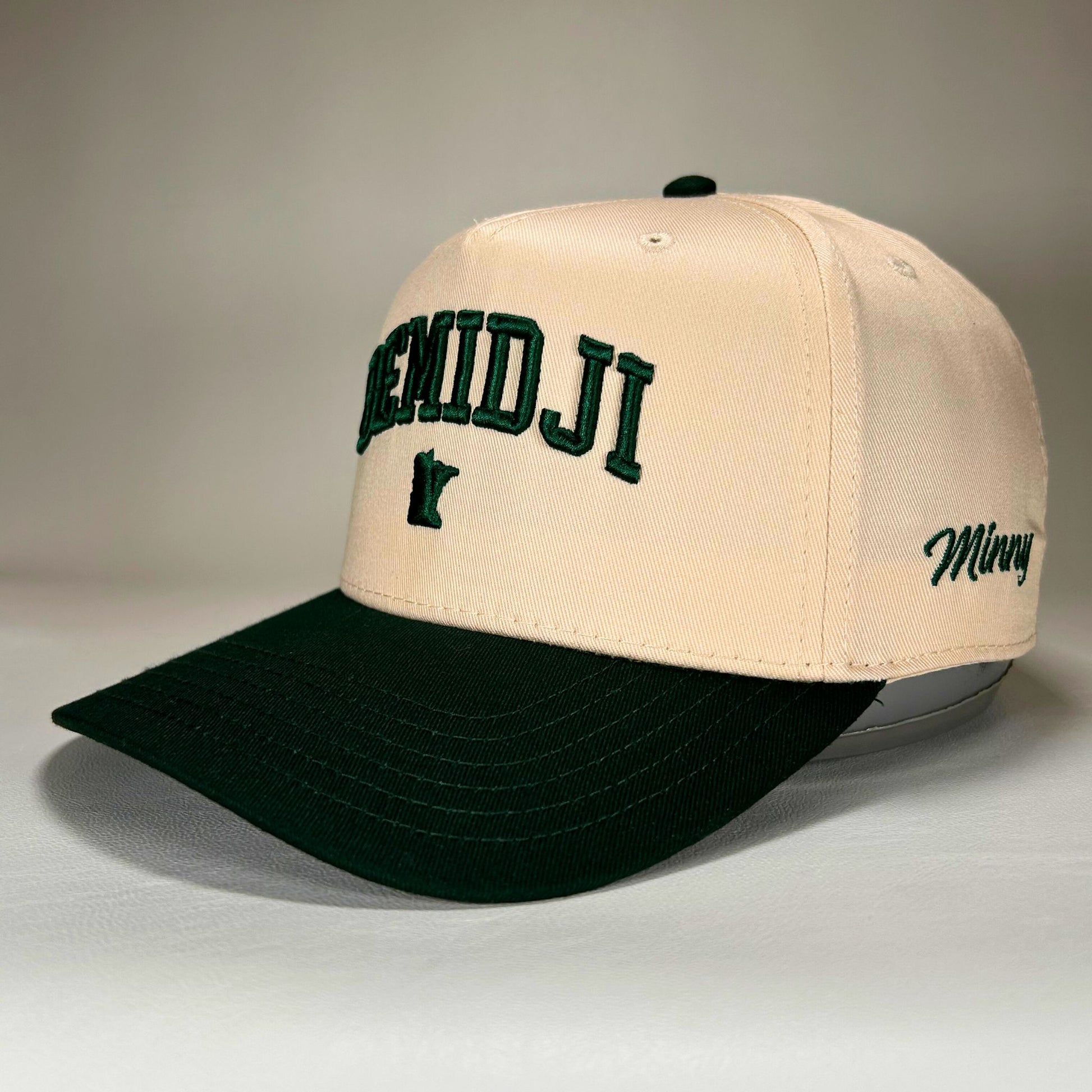 Side view of natural and green Bemidji 5-panel cap with puff lettering